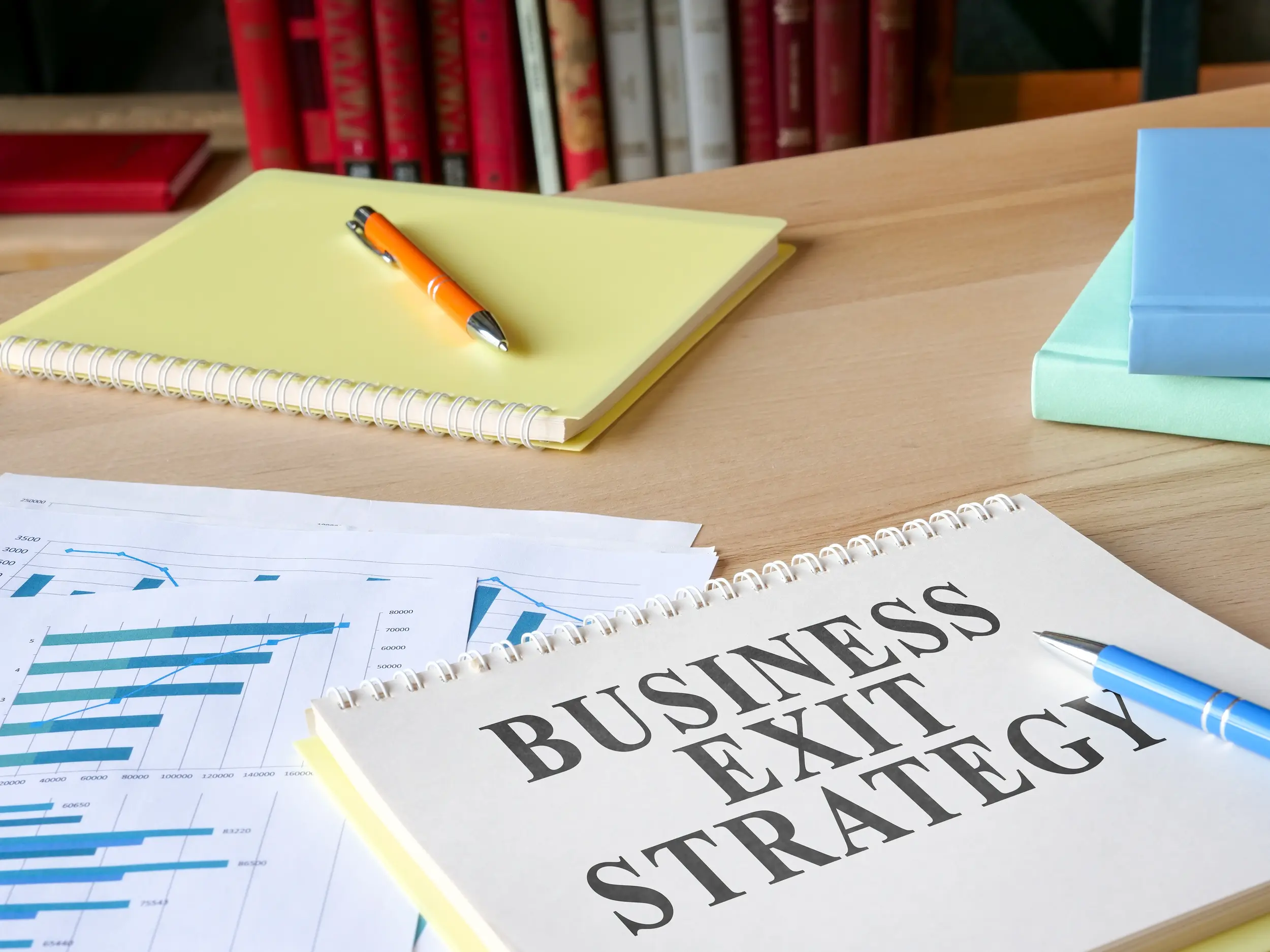 Business exit strategy plan and financial charts on a desk for reviewing exit options
